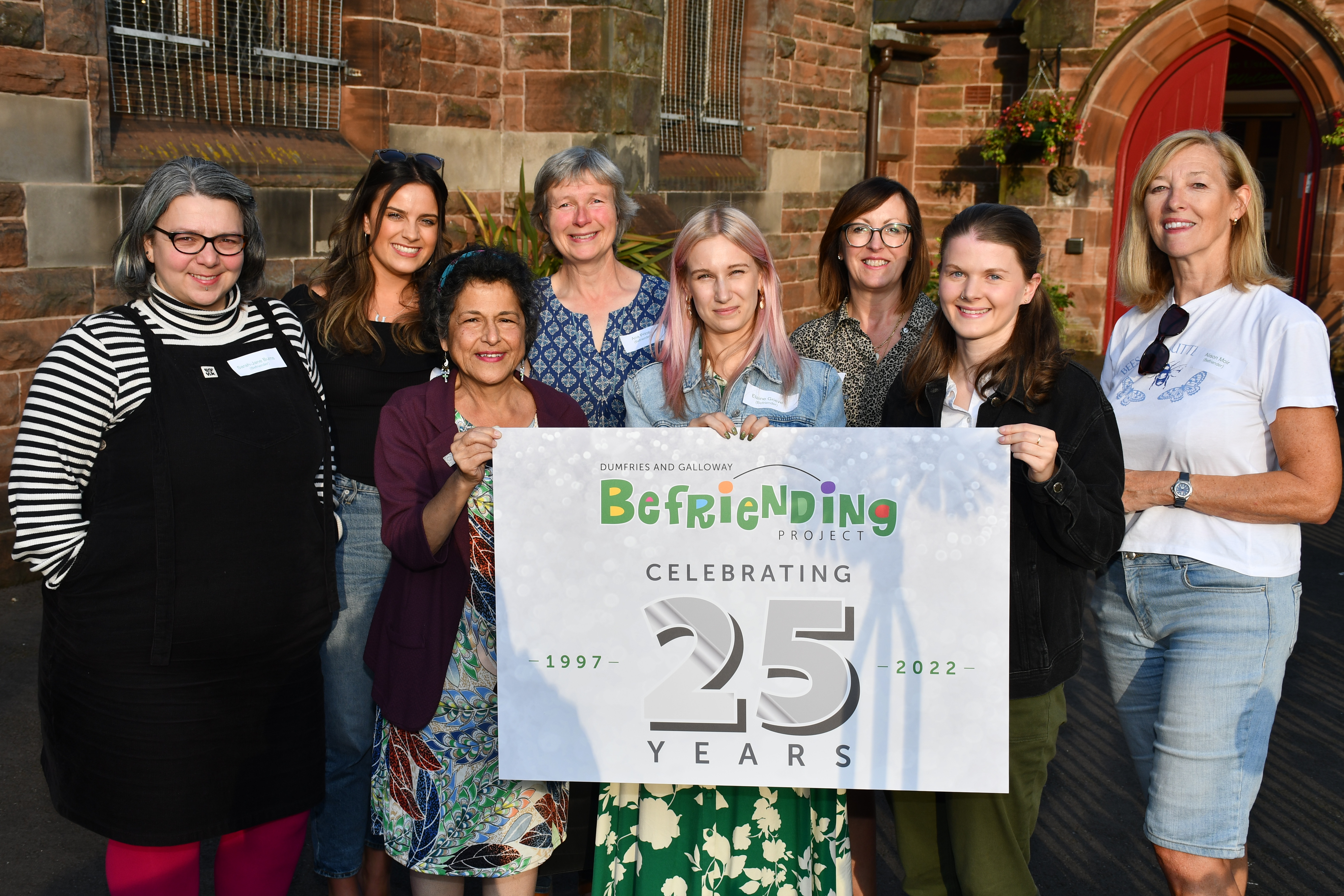 Some of the befrienders who volunteer with the Dumfries & Galloway Befriending Project with a 25th anniversary banner.