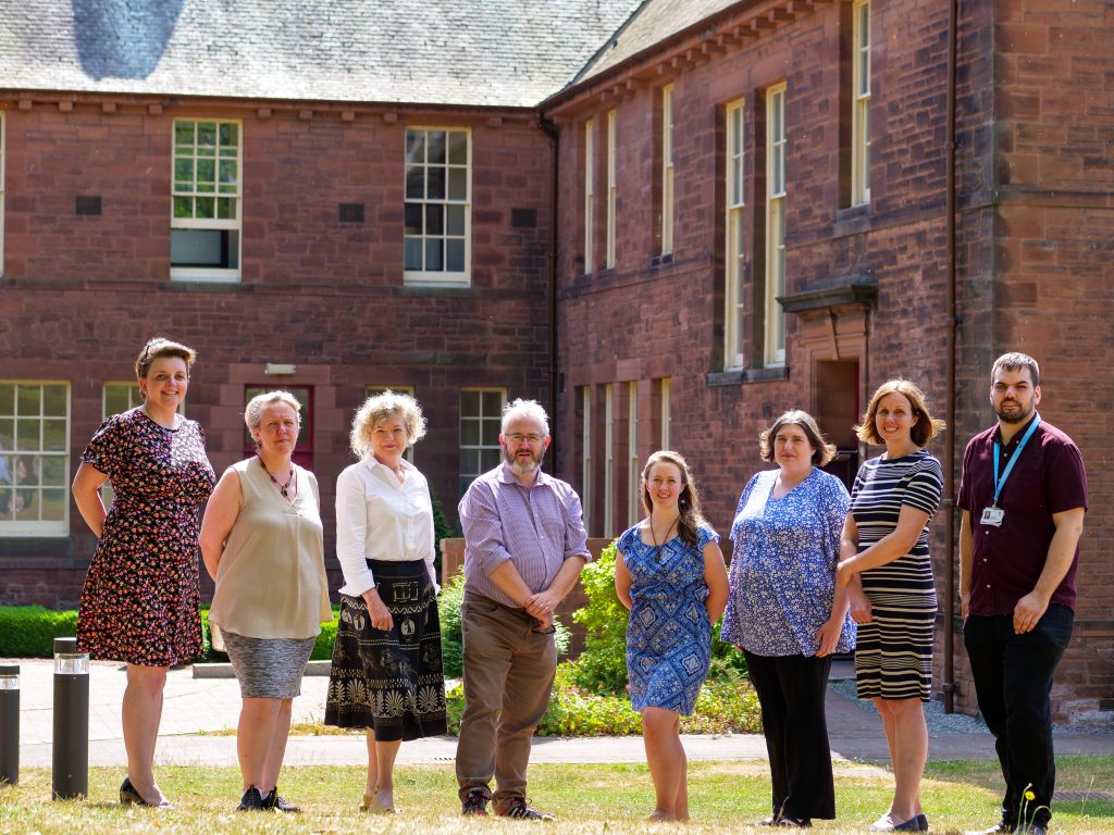 From left: Niomi Nichol, Health and Social Care Engagement Manager; Iona Callum, Programme Co-ordinator; Norma Austin Hart, Chief Executive Officer; John Dougan, TSDG Board Chair; Rachel Muir, Community Engagement Officer (Funding); Carol Bell, Hospital to Home Wraparound Coordinator; Claire Brown, Head of Operations; and Dan Allan, Information and Communications Officer.