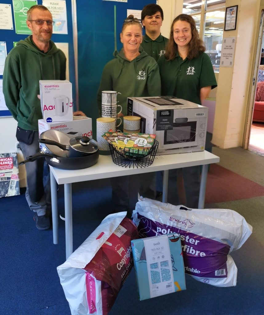 The team at SHAX with one of their starter packs as part of the Making a House into a Home project.